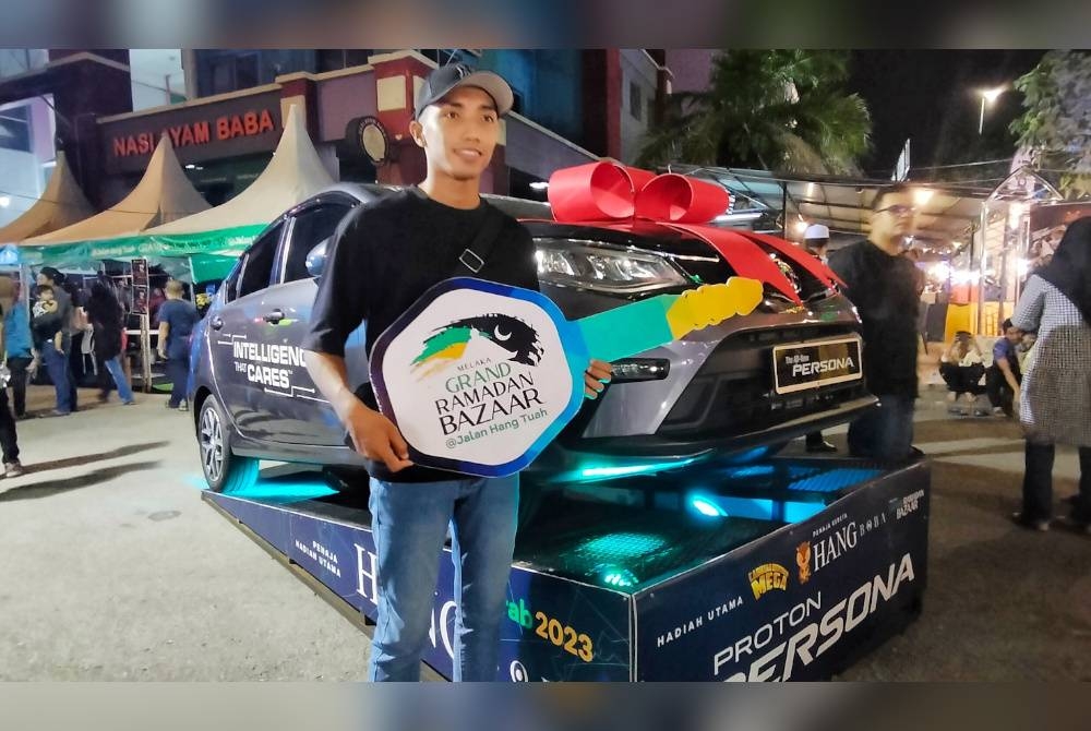 Muhamad Sharul Aiemi bergambar bersama replika kunci dan kereta yang dimenanginya sempena cabutan nombor bertuah Melaka Grand Ramadan Bazar @Jalan Hang Tuah (MELGRAB) di sini, pada malam Ahad.