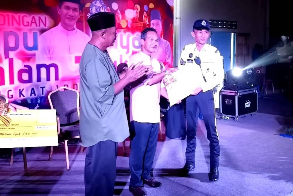 Rohaimi (tengah) menyampaikan hadiah kepada pemenang sempena pertandingan lampu raya malam tujuh likur peringkat IPD Kemaman.