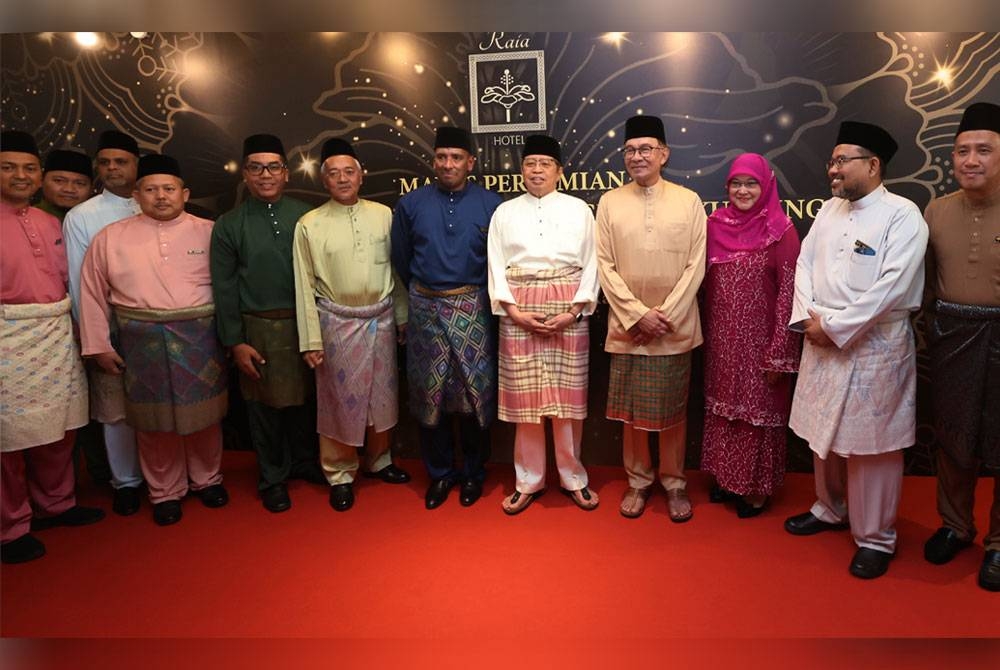 Anwar bergambar dengan kakitangan hotel pada Majlis Perasmian Rais Hotel dan Convention Centre Kuching dan Majlis Berbuka Puasa Bersama Asnaf dan Anak Yatim hari ini. Foto Bernama