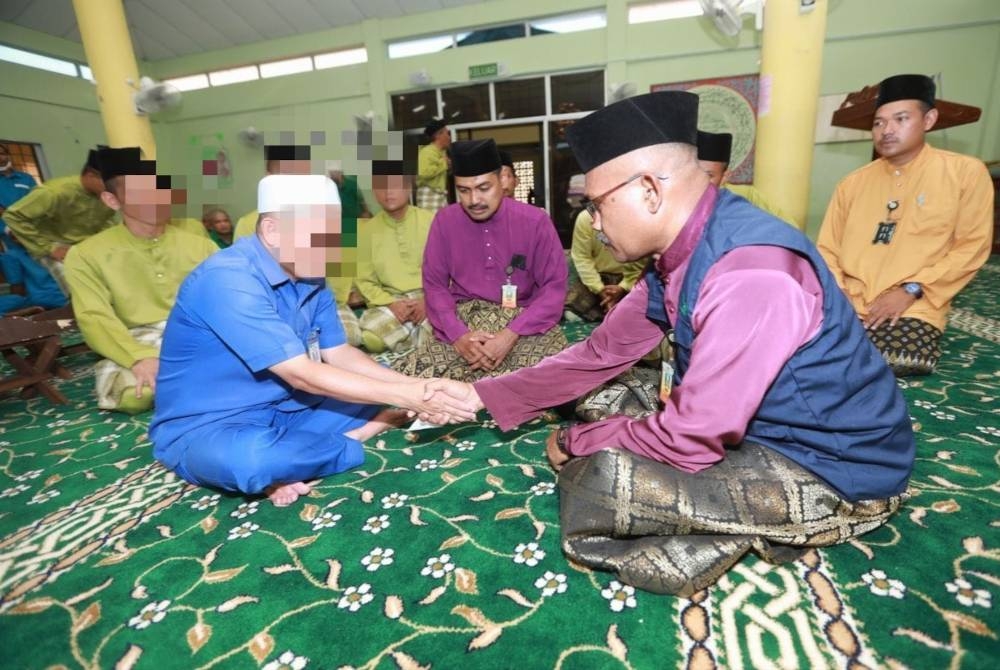 Salah seorang banduan di Penjara Penor membayar zakat fitrah kepada amil yang dilantik.