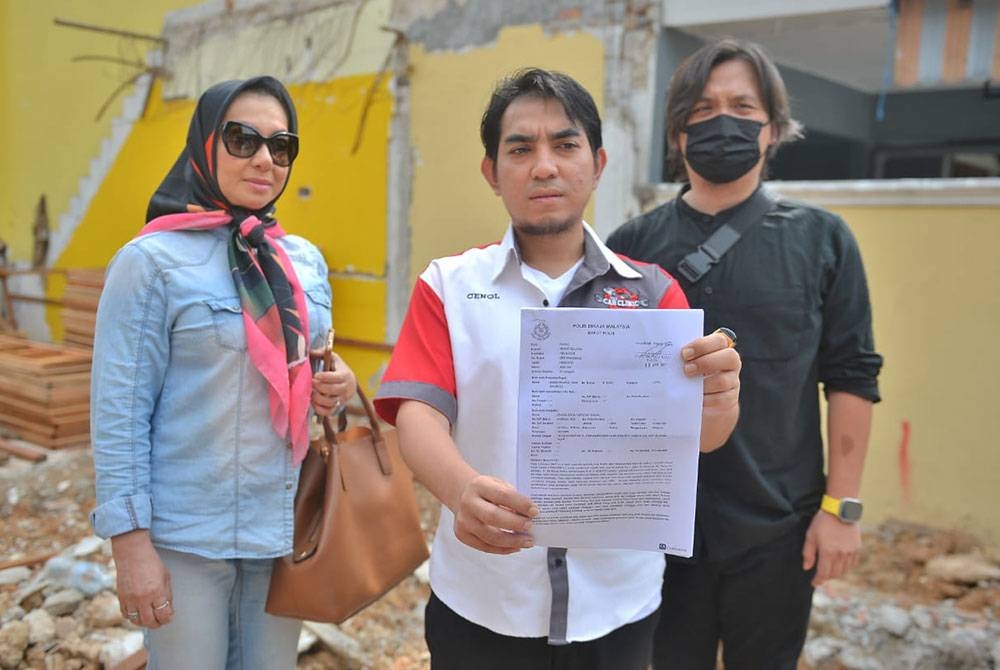 Zainol D&#039;zul Hafiz Zainal(tengah) menunjukkan laporan polis yang dibuat di Ibu Pejabat Polis Daerah (IPD) Klang Selatan untuk tindakan lanjut.