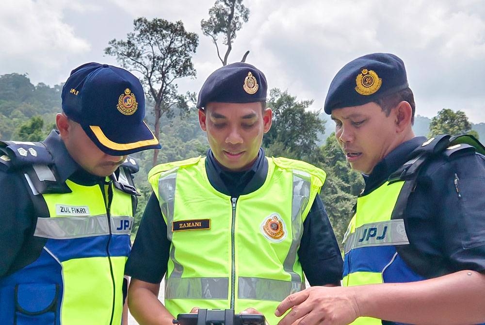 Mohd Alifarihan (kanan) melihat pemantauan dengan menggunakan dron di kawasan berhampiran Terowong Menora, Ipoh pada Rabu.