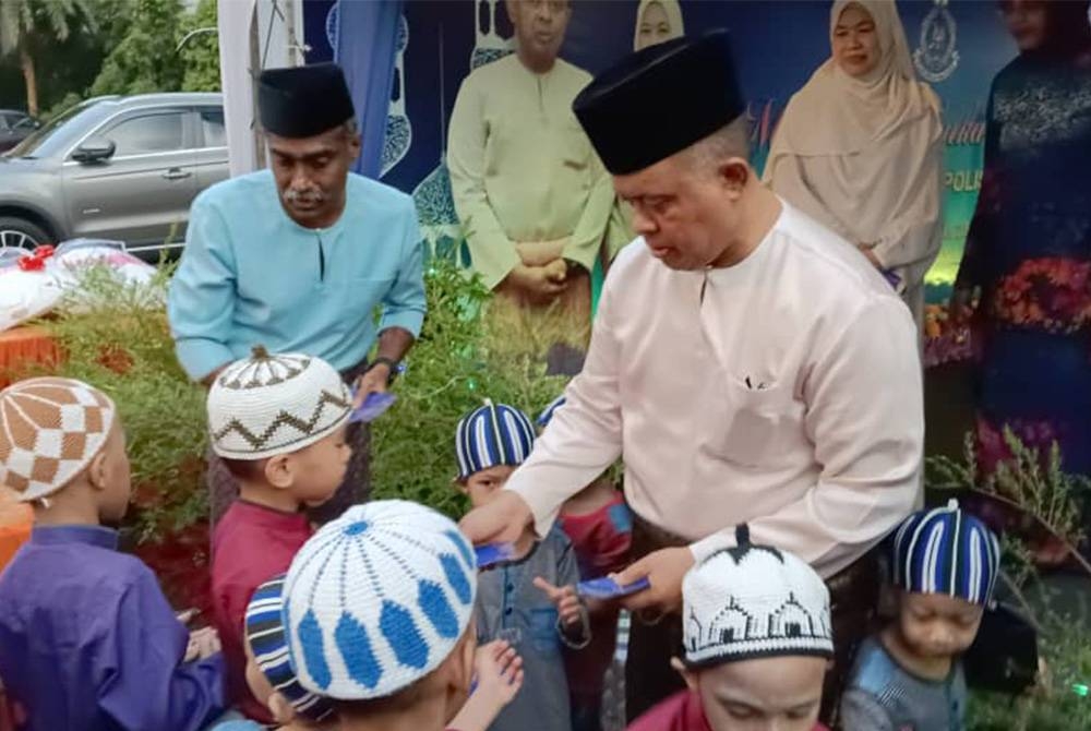 Kamarul Zaman (tengah) menyaksikan penyerahan sumbangan kepada keluarga anggota polis yang menjadi mangsa banjir dalam Majlis Berbuka Puasa IPK Johor Tahun 2023 di Masjid Tunku Laksamana Abdul Jalil, Johor Bahru pada malam Rabu