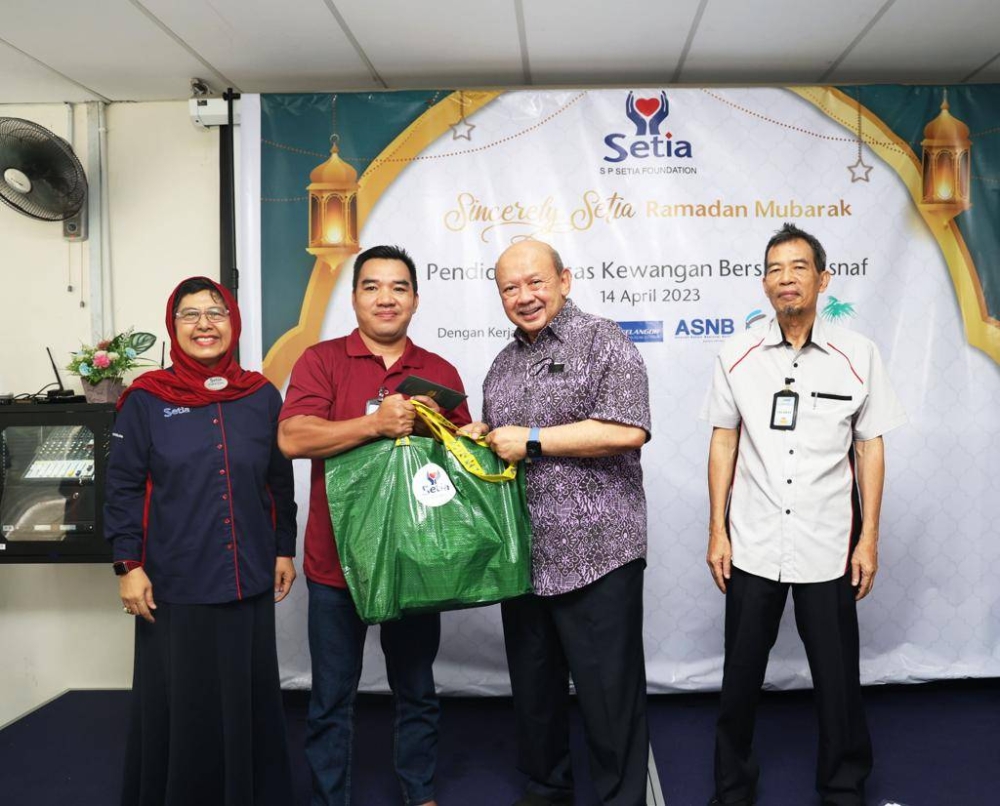 Syed Anwar (dua dari kanan) menyampaikan Bakul Syawal kepada salah seorang penerima selepas merasmikan majlis tersebut.