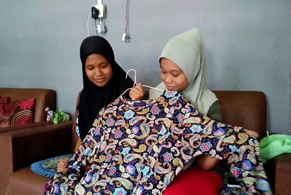 Jubah milik ibu menjadi pengubat rindu buat Nur Anis Syafika (kanan) dan Nur Izatul Farisha menjelang Hari Raya Aidilfitri tahun ini.