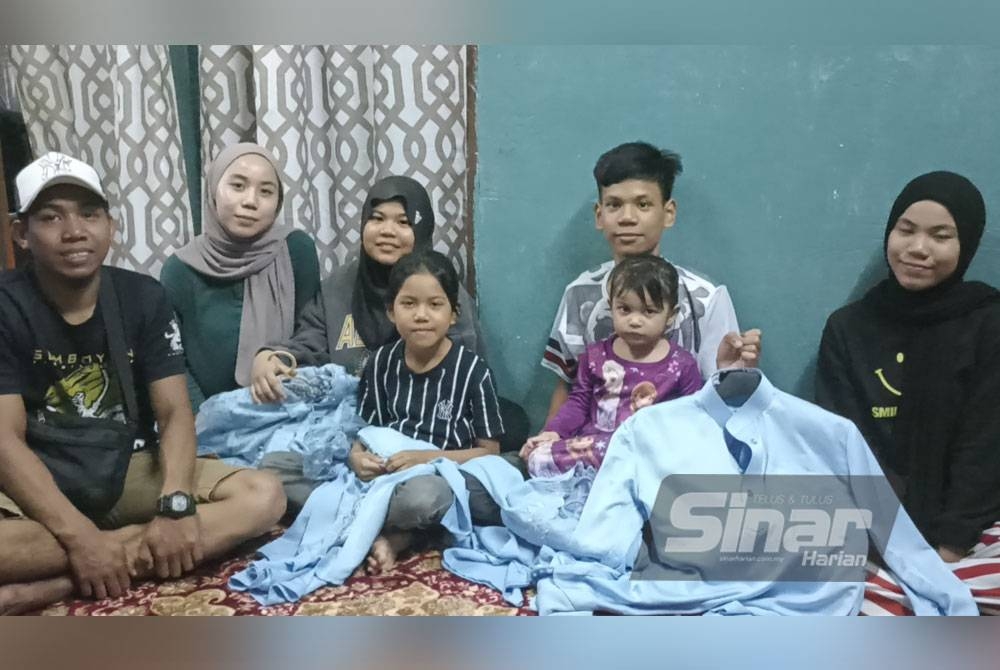 Nurin (dua dari kiri) bersama adik-beradik menunjukkan baju raya yang dibeli along di rumah pangsa Skudai Kanan.