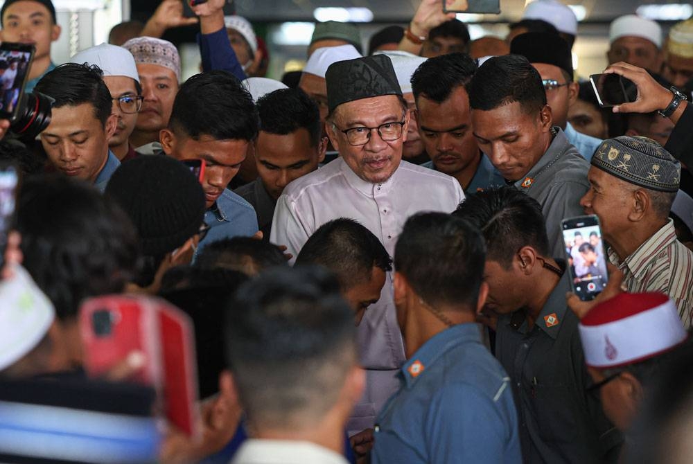 Anwar beramah mesra bersama para jemaah selepas selesai menunaikan solat Jumaat di Masjid As-Salam, Taman Petaling Utama. - Foto Bernama