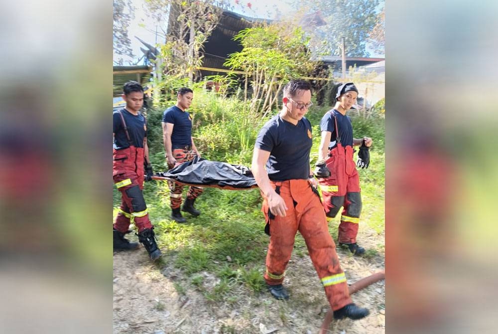 Mangsa rentung dikeluarkan dari rumah yang terbakar sebelum diserahkan kepada pihak polis.