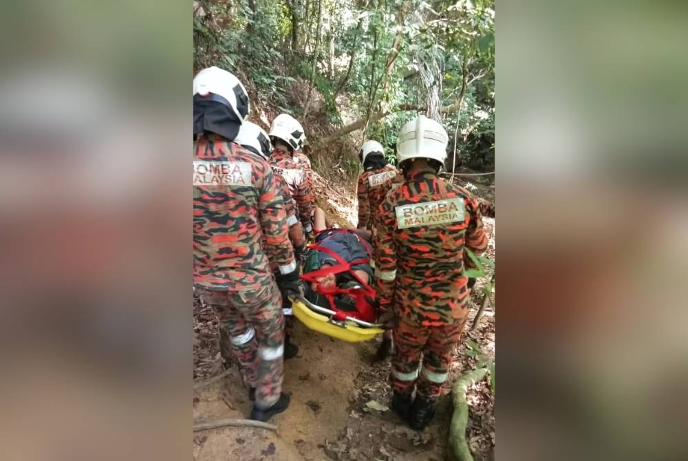 Anggota menggunakan pengusung untuk menurunkan mangsa pada ketinggian 170 meter. - Foto Bomba Perak