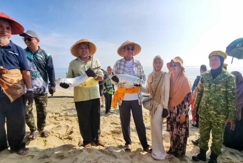 Ahmad Samsuri (empat dari kanan) bersama isteri, Toh Puan Seri Tuan Faezah Tuan Abd Rahman (dua dari kanan) dan Exco Pelancongan, Kebudayaan dan Teknologi Digital Terengganu, Ariffin Deraman (tiga dari kiri) ketika menghadiri program Tarik Pukat Raya 2023 di Pulau Kekabu, Marang.