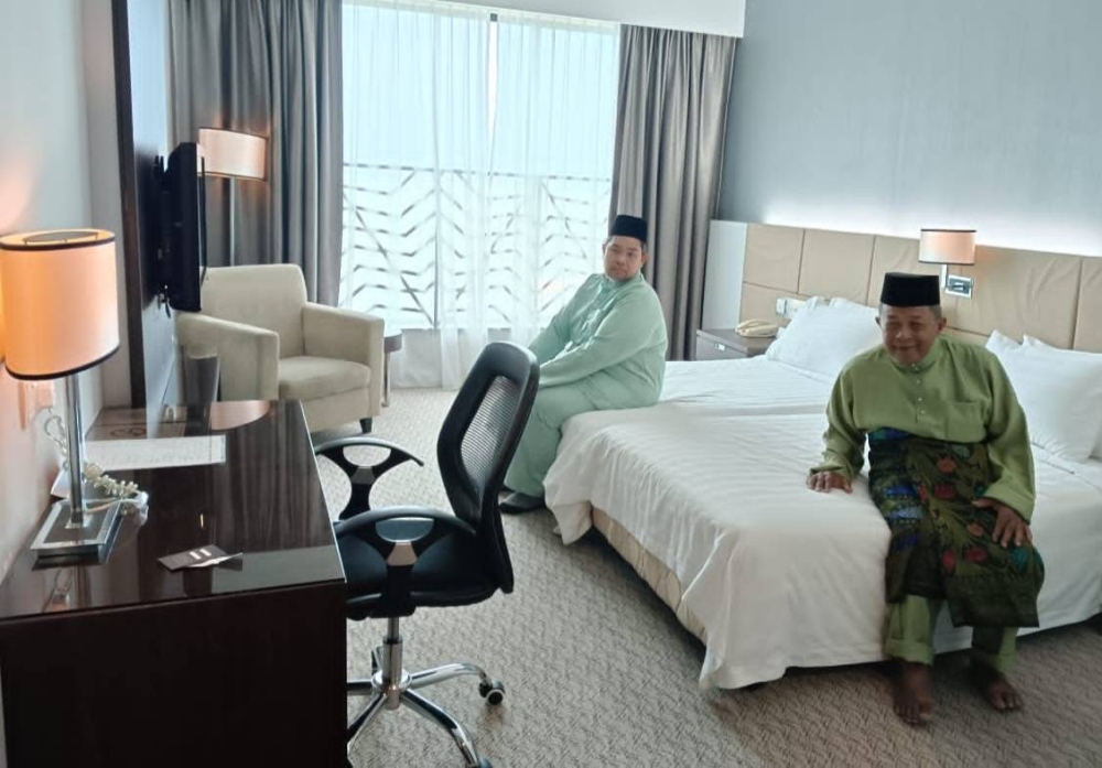 Azmi (kiri) bersama salah seorang penghuni yang turut meraikan Aidilfitri di sebuah hotel terkemuka di Alor Setar.