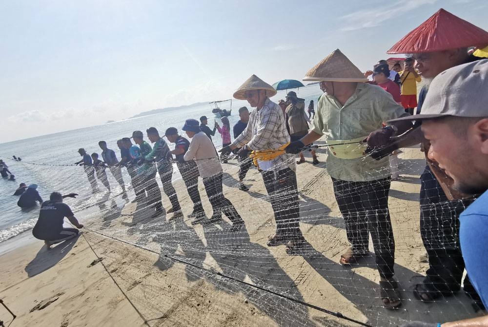 Ahmad Samsuri (empat dari kanan) ketika menyertai Program Tarik Pukat Raya 2023 di Pantai Pulau Kekabu, di Marang pada Isnin.