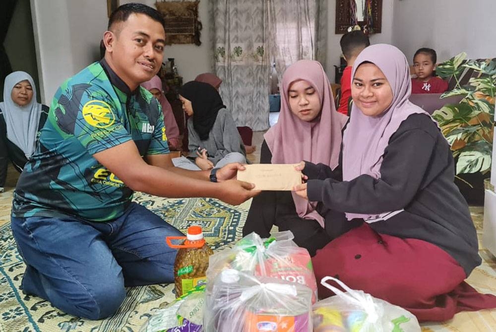 Presiden EOCM, Hezri Kusrin menyampaikan sumbangan kepada Nur Farysya Eryany ketika kunjungan ke rumahnya di Taman Seri Balok Kuantan baru-baru ini.