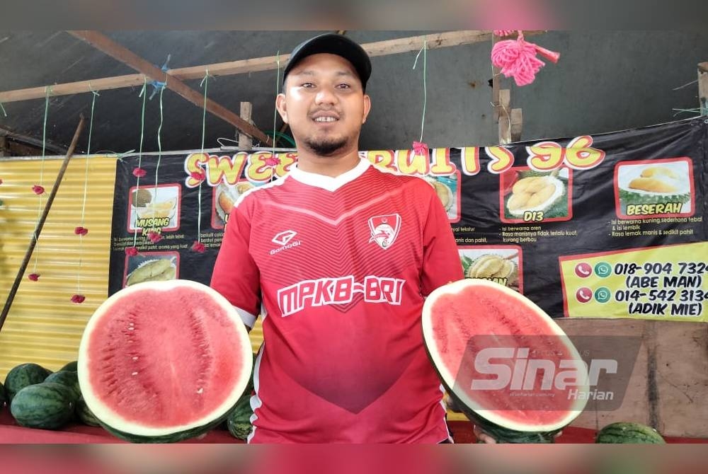 Abdul Muhaimi menunjukkan tembikai yang dijual di gerai buahnya.