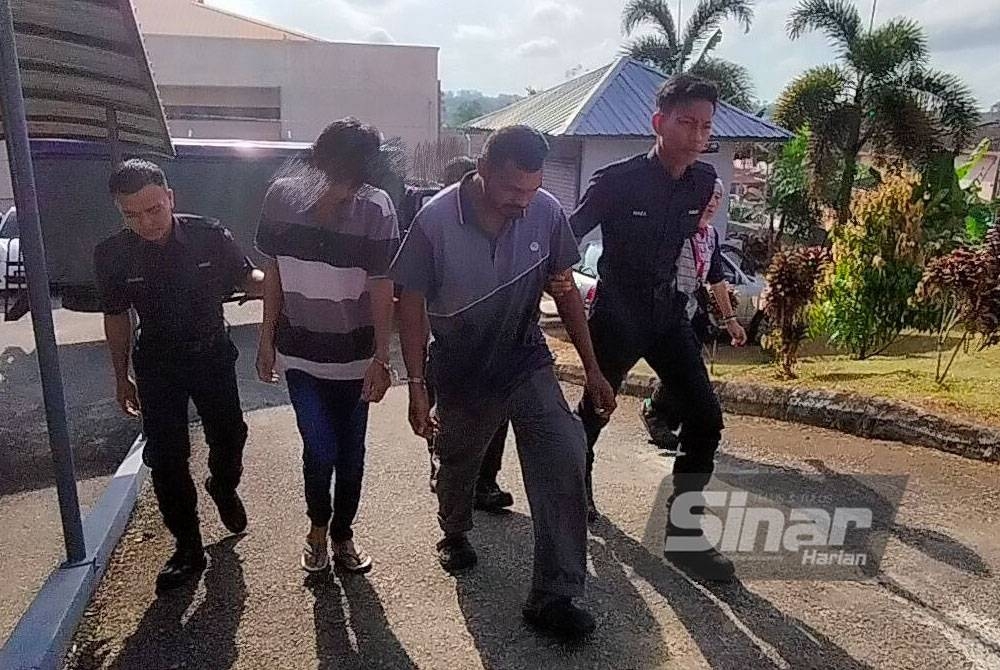 Tertuduh (dua dari kanan) diiringi anggota polis sebaik tiba di pekarangan Mahkamah Majistret Kuala Pilah.