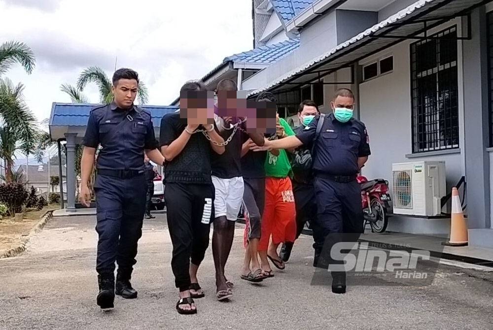 Tertuduh (dua dari kiri) diiringi anggota polis ke Mahkamah Majistret Kuala Pilah.