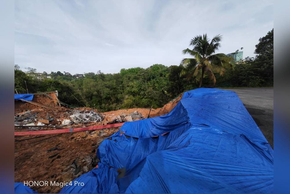 Jabatan Kerja Raya memasang kanvas di kawasan tanah yang runtuh.