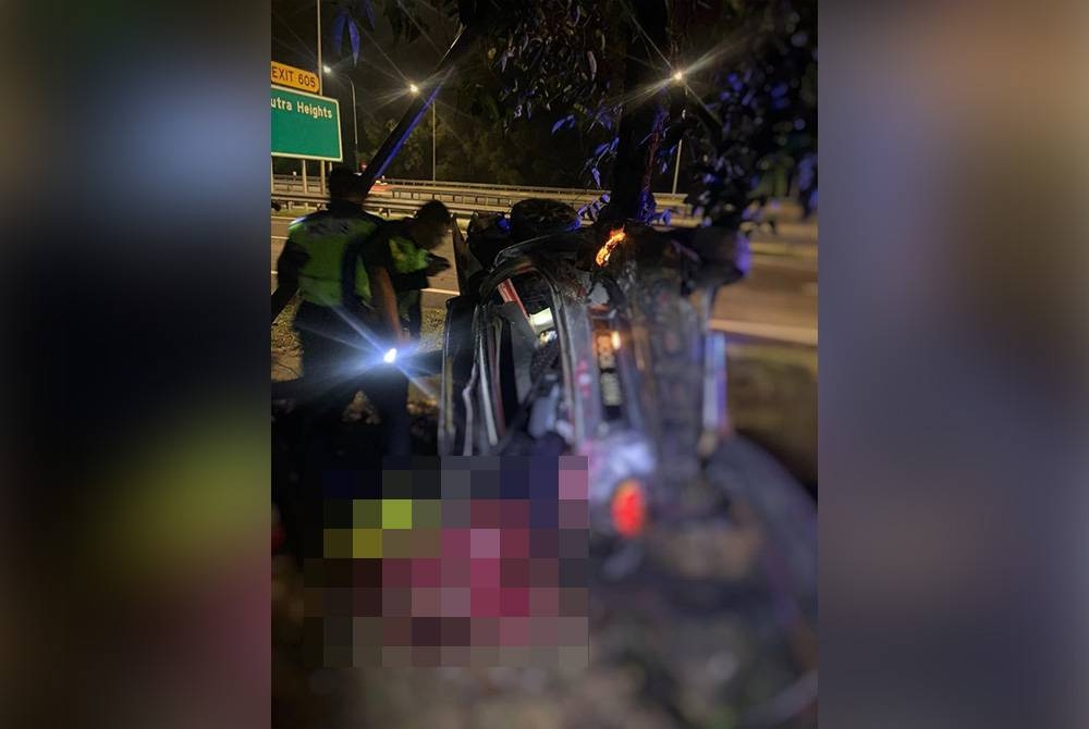 Anggota polis memeriksa keadaan kereta yang terbabas dalam kejadian di susur keluar Putra Heights, Lebuhraya Elite di sini pada Khamis.