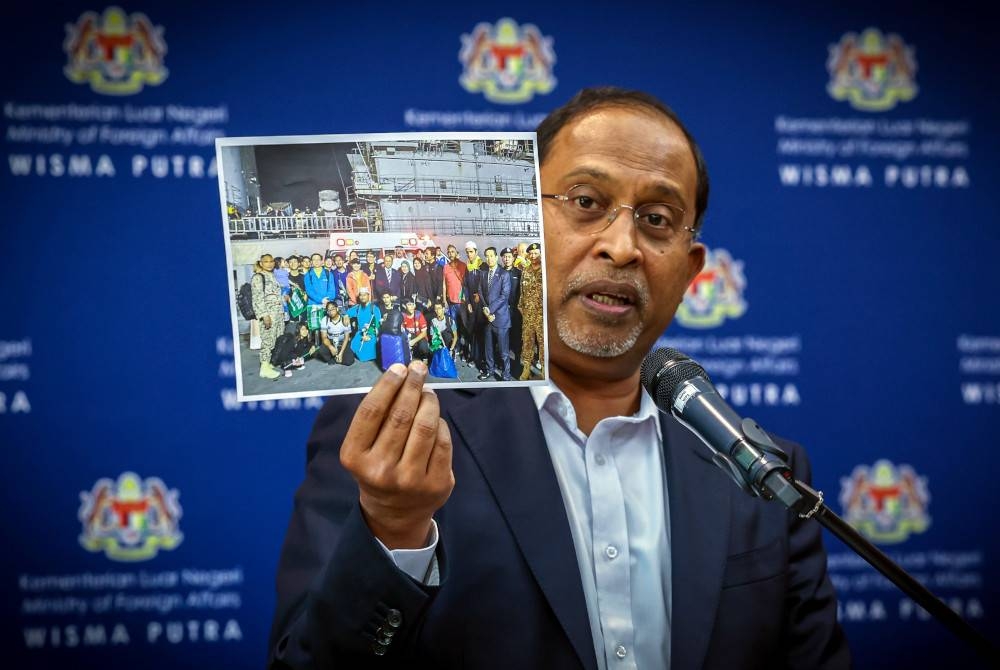 Zambry menunjukkan gambar rakyat Malaysia yang dibawa keluar dari Sudan pada sidang media di Wisma Putra hari ini. - Foto Bernama