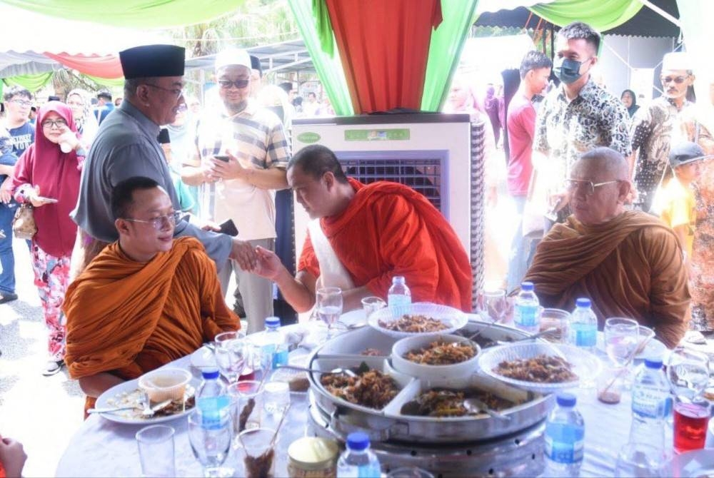 Muhammad Sanusi (kiri) bersalaman dengan tetamu yang turut dihadiri pelbagai agama dan bangsa. - Foto Urus Setia Penerangan Darul Aman (UPDA)