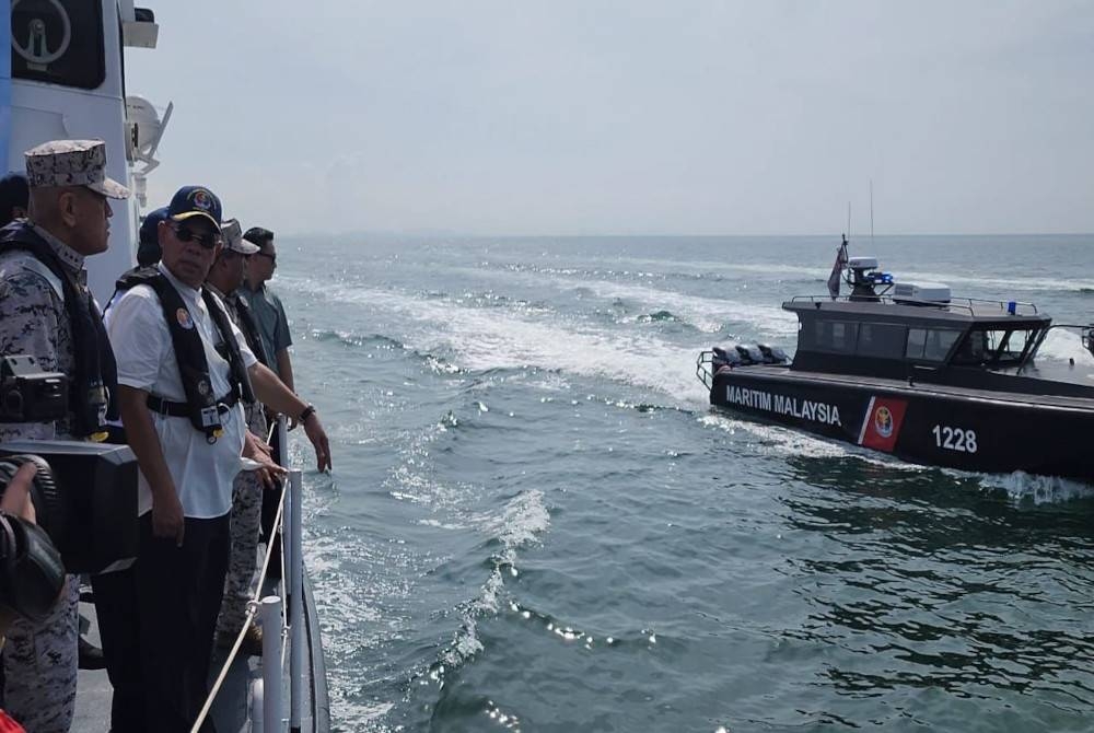 Saifuddin Nasution (dua dari kiri) meninjau keadaan perairan di Pulau Pinang bersama kru Kapal Maritim Burau pada Jumaat.