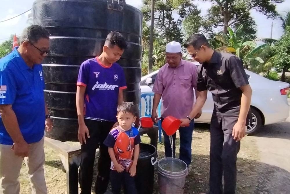 Mohd Fared (kanan) meninjau penggunaan tangki statik di Kampung Parit Puasa, pada Jumaat.