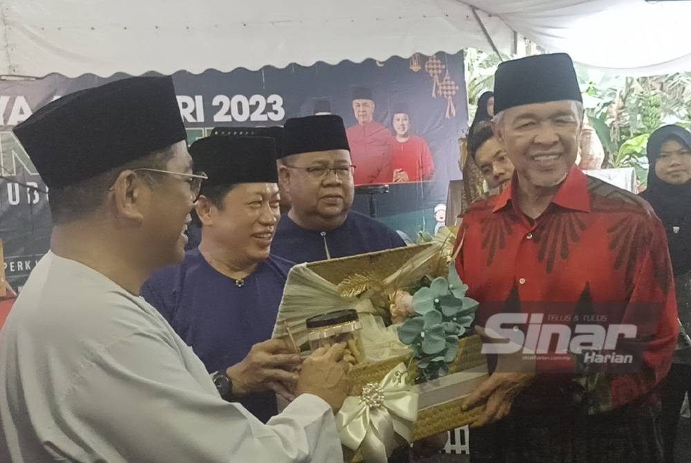 Ahmad Zahid (kanan) menerima cenderamata daripada Ahmad (tengah) pada Majlis Rumah Terbuka UMNO Bahagian Pontian di Dewan Muafakat Kompleks Pusat Khidmat Ahli Parlimen Pontian di Benut pada Jumaat.