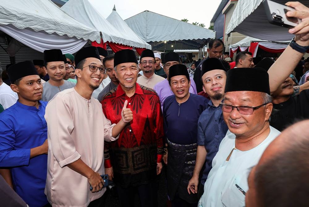 Ahmad Zahid (tiga, kiri) bersama Ahmad (empat, kiri) beramah mesra bersama tetamu yang hadir pada Majlis Rumah Terbuka Hari Raya Aidilfitri UMNO Pontian di Benut pada Jumaat. - Foto Bernama