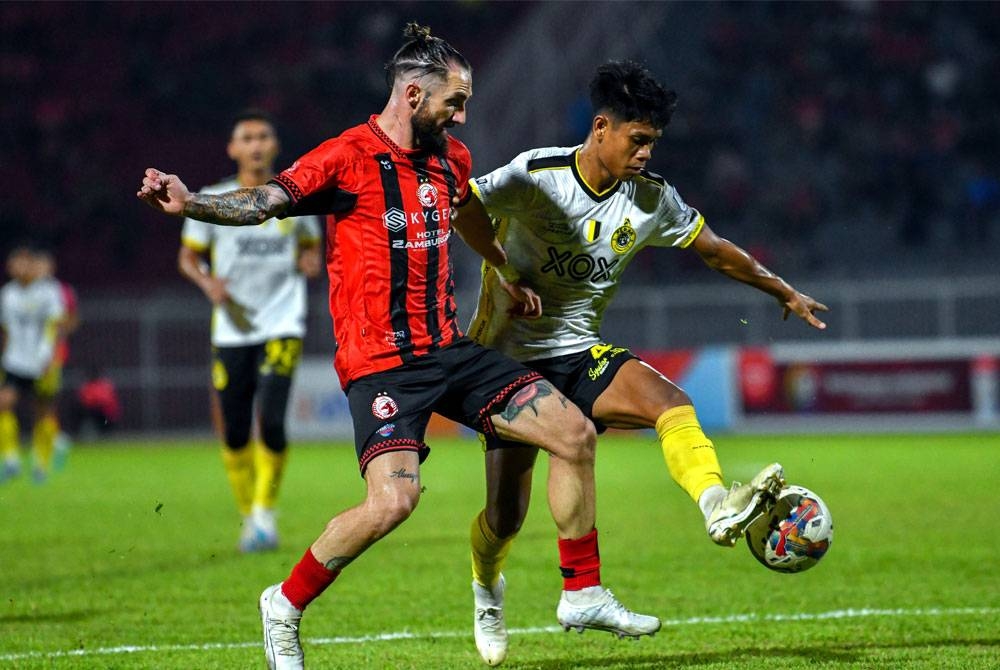 Pemain pasukan Perak FC, Muhammad Nasrol Amri Kamarul Azhar (kanan) mengawal bola daripada pemain pasukan Kelantan FC, Miguel Angel Garrido Cifuentes (kiri) pada perlawanan Liga Super 2023 di Stadium Sultan Muhammad Ke-IV malam ini. - Foto Bernama