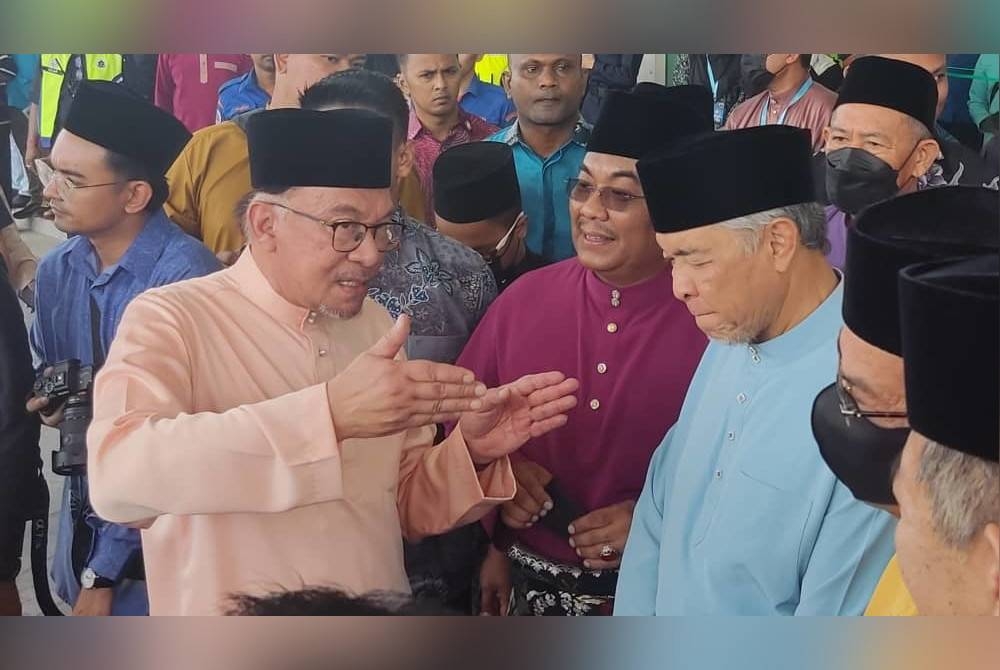 Anwar berkata sesuatu kepada Muhammad Sanusi dan Ahmad Zahid ketika menunggu keberangkatan tiba Sultan Kedah di Rumah Terbuka Malaysia Madani di Alor Setar pada Sabtu.