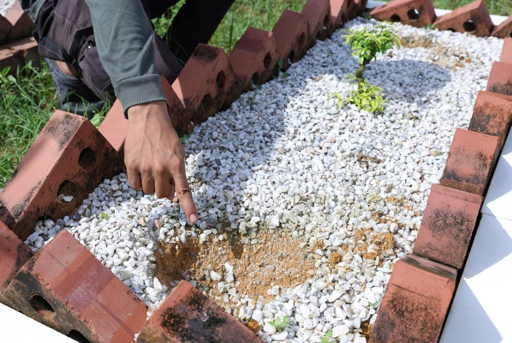 Muhammad Izzul Hafiq menunjukkan salah satu batu nisan daripada 11 kubur yang dicuri ketika ditemui pengamal media di Tanah Perkuburan Islam Mukim Tebrau di Taman Istimewa, Pandan. - Foto Bernama