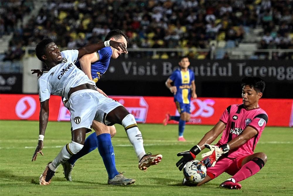 Pemain TFC Jordan Mintah (kiri) diasak penjaga gol Sri Pahang Izham Tarmizi Roslan pada perlawanan Liga Super di Stadium Sultan Mizan Zainal Abidin.