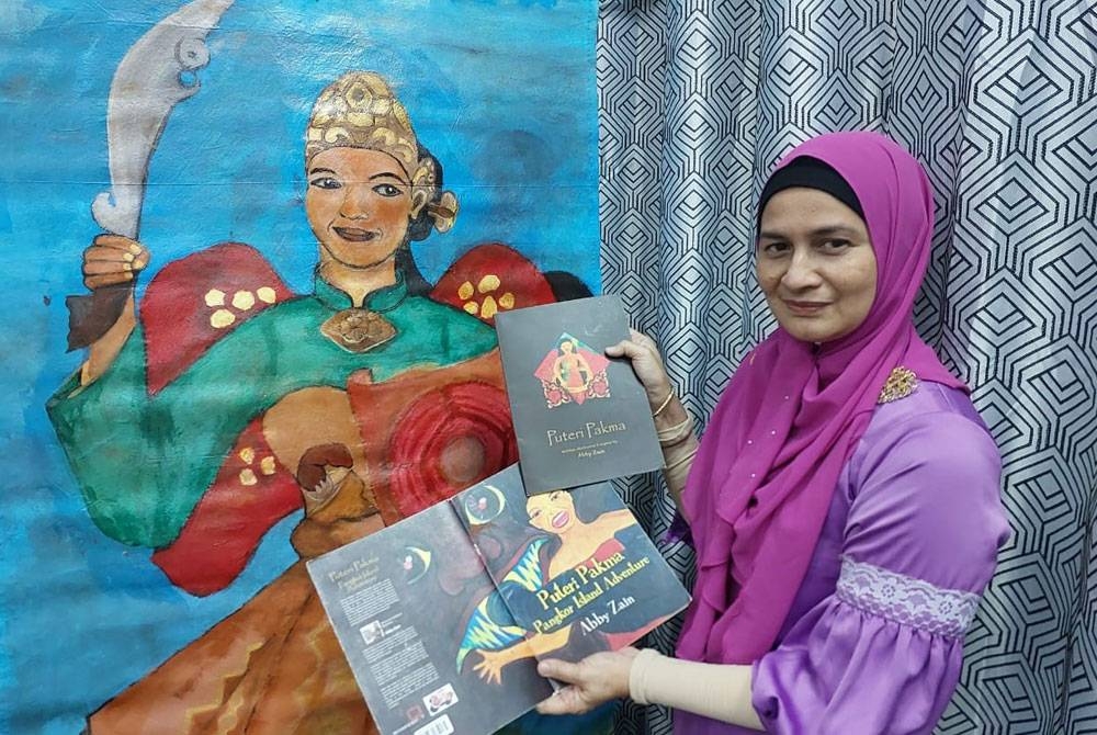 Abby Zain menunjukkan buku cerita bergambar berjudul Puteri Pakma dan hasil lukisannya.