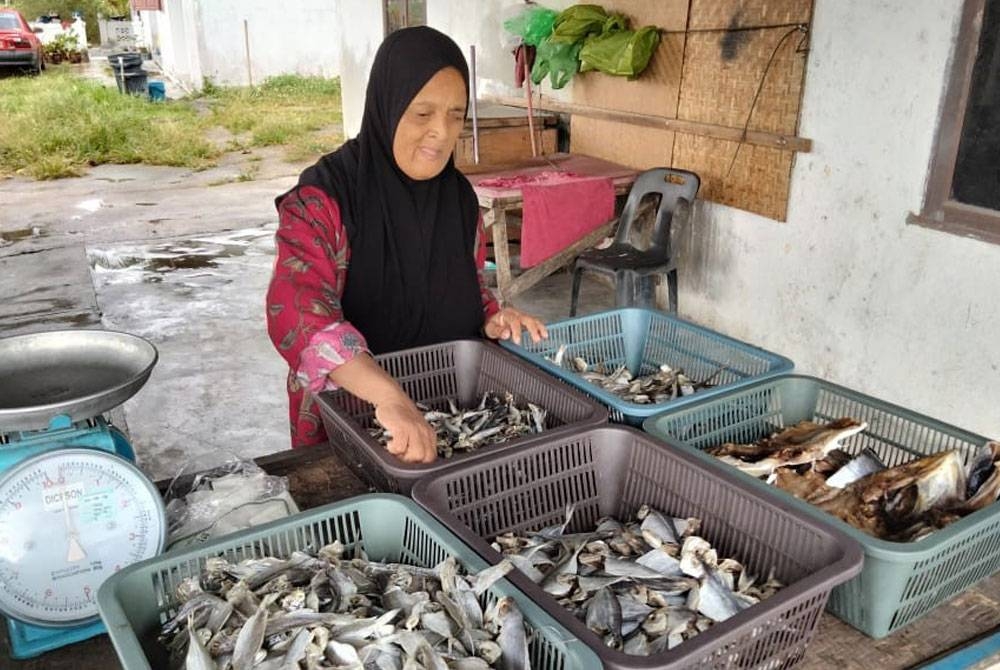 Jamilah menunjukkan pelbagai jenis ikan yang sedia untuk dijual.