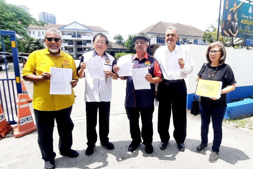 Abdul Razak (kiri) bersama pimpinan MDMM tampil membuat laporan di Balai Polis Puchong Jaya pada Isnin.