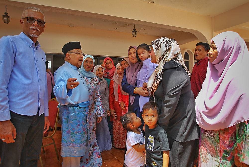 Bibi Sharliza (tiga dari kiri) dan Mohd Isa (dua dari kiri) beramah mesra dengan orang ramai yang datang ke rumah terbuka mereka di Kampung Baru, Port Dickson.