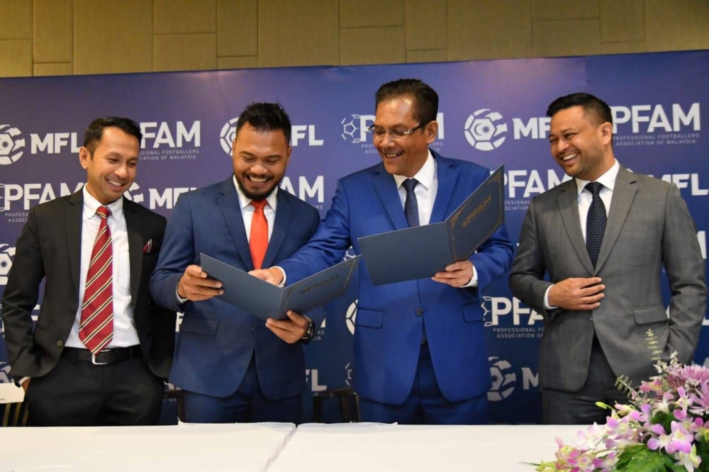 Ab Ghani (dua dari kanan) dan Safee (dua dari kiri) memperkatakan sesuatu pada majlis menandatangani Perjanjian Kolaborasi antara MFL dan PFAM di Kuala Lumpur pada Selasa. - Foto: MFL