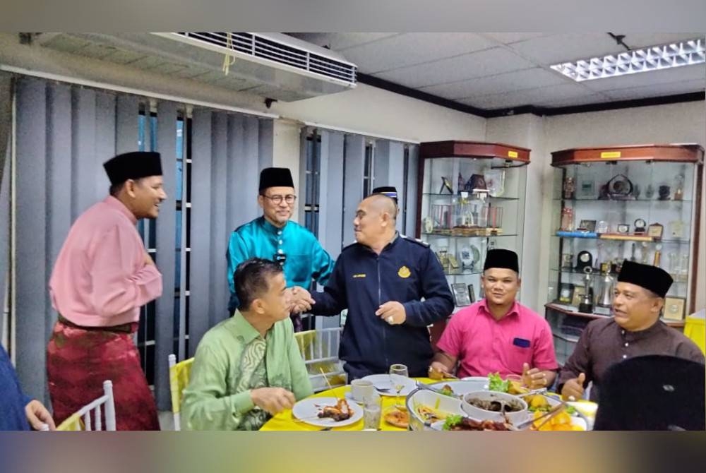 Azman (dua dari kiri) melayan tetamu pada Majlis Rumah Terbuka Hari Raya Aidilfitri KPDN pada Rabu.