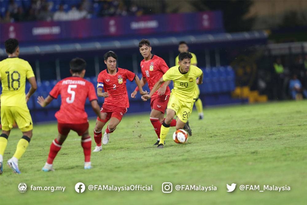 Pemain negara, Aiman Afif cuba melepasi kawalan pemain Laos dalam aksi di Stadium Prince, Phnom Penh pada Rabu.