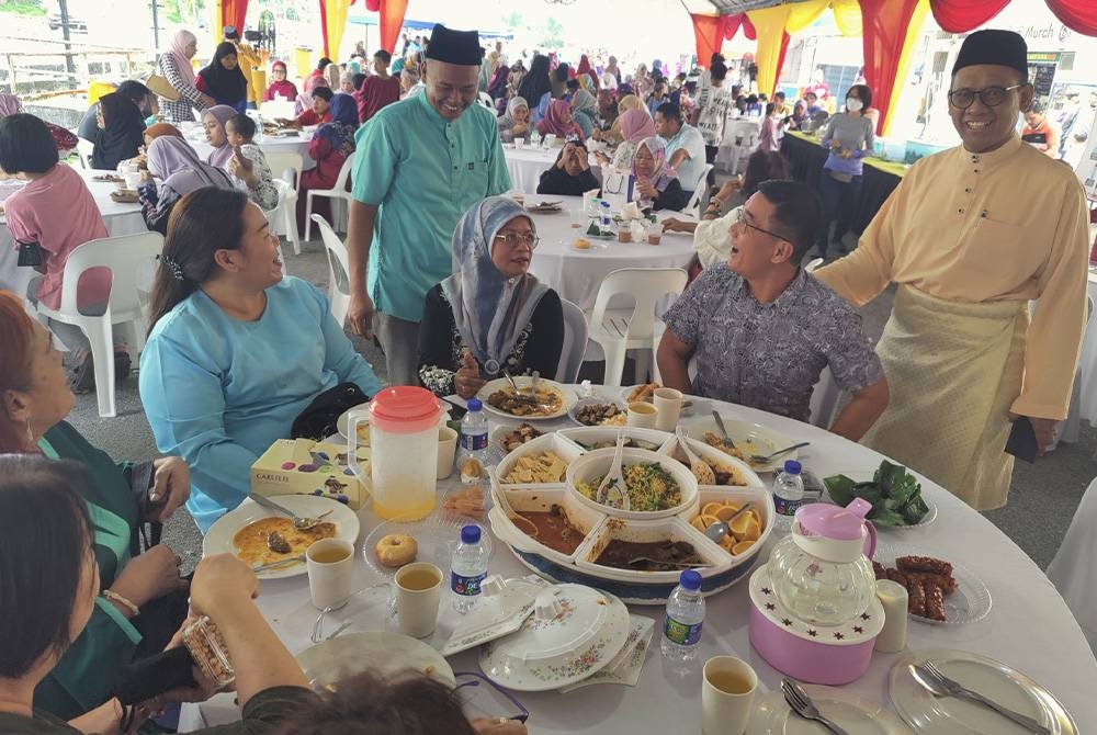 Mohd Yahya (berdiri, kanan) beramah mesra pada Majlis Mesra Aidilfitri DUN Permatang di pekarangan Pusat Khidmat ADUN Permatang pada Sabtu.