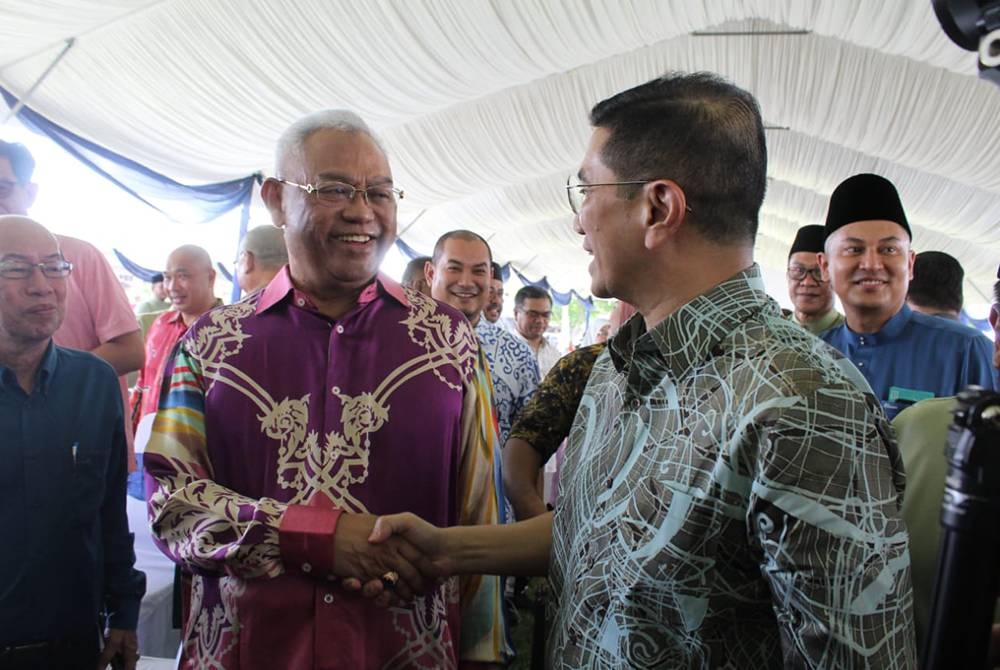 Noh (kiri) disambut Mohamed Azmin ketika hadir Majlis Silaturrahmi Aidilfitri DUN Gombak Setia pada Sabtu.