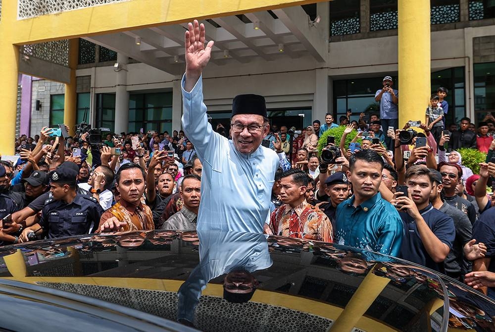 Anwar melambaikan tangan kepada orang ramai pada Rumah Terbuka Malaysia MADANI di UiITM Cawangan Pulau Pinang hari ini. Foto Bernama