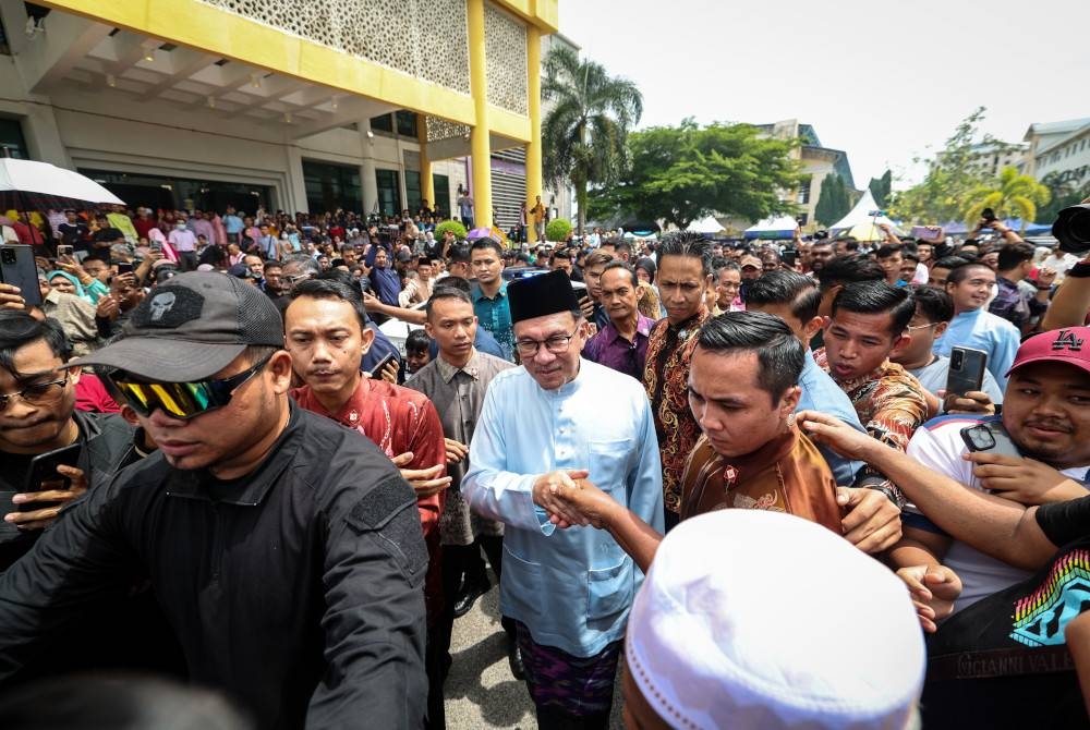 Anwar bersalaman dengan orang ramai pada Majlis Rumah Terbuka Malaysia Madani di UiTM Cawangan Pulau Pinang hari ini. - Foto Bernama