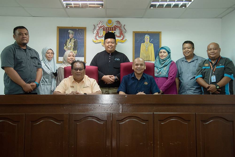 Armizan (duduk, kanan) bergambar bersama kakitangan Pejabat Mahkamah Anak Negeri Labuan pada program lawatan kerja, pada Sabtu. - Foto Bernama