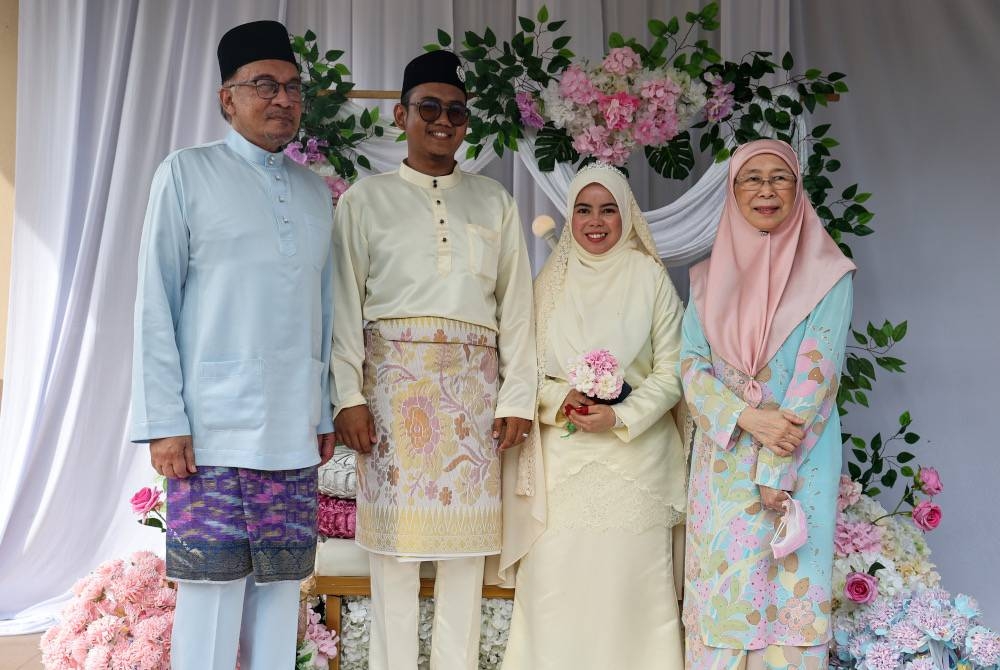 Anwar dan Dr Wan Azizah Wan bergambar bersama pasangan pengantin Mohammad Farhan dan Nurul Fatienul ketika menghadiri majlis kenduri kahwin pasangan itu di Kampung Pelet, pada Sabtu. - Foto Bernama