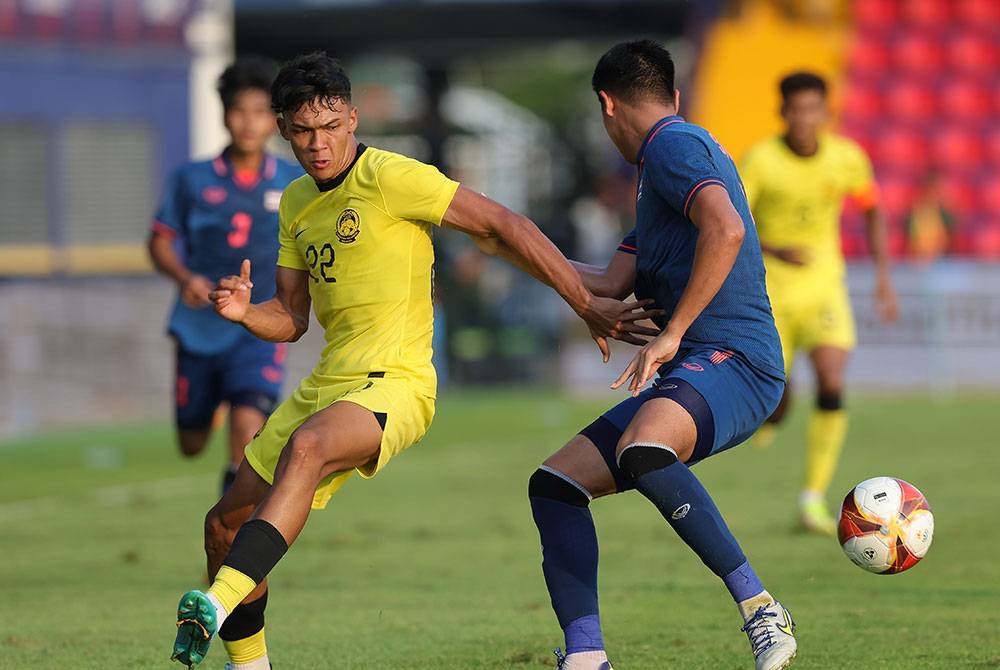 Pemain Malaysia, Muhammad Haqimi Azim Rosli dihalang pemain Thailand Songchai Thongcham pada perlawanan Bola Sepak Peringkat Kumpulan B sempena Sukan SEA 2023 di Stadium Prince, pada Sabtu. - Foto Bernama