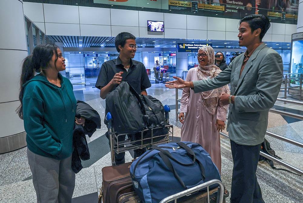 Junaidah bersama dua anaknya sejurus tiba di KLIA Terminal 1 dari Jeddah pada Ahad setelah selamat keluar dari Sudan. - Foto Bernama