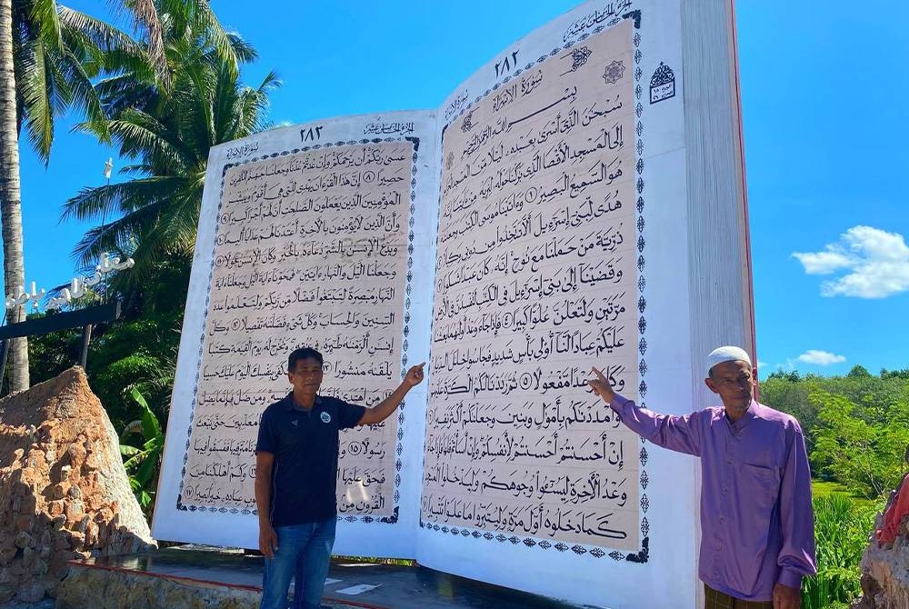 Thalib (kiri) dan Mat Rokey (kanan) menunjukkan replika al-Quran gergasi dengan ketinggian 3.6 meter, lebar 5.2 meter di Kampung Pa Pungoh, Yala.