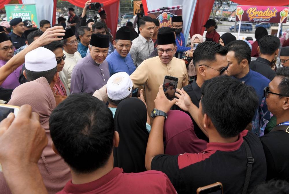 Anwar (tiga dari kanan) bersama Ahmad Zahid (tiga dari kiri) diiringi Aminuddin (lima dari kanan) bersalaman dengan orang ramai ketika hadir pada Rumah Terbuka Aidilfitri Negeri Sembilan dan Malaysia Madani di Wisma Majlis Bandaraya Seremban (MBS), pada Ahad. - Foto Benama