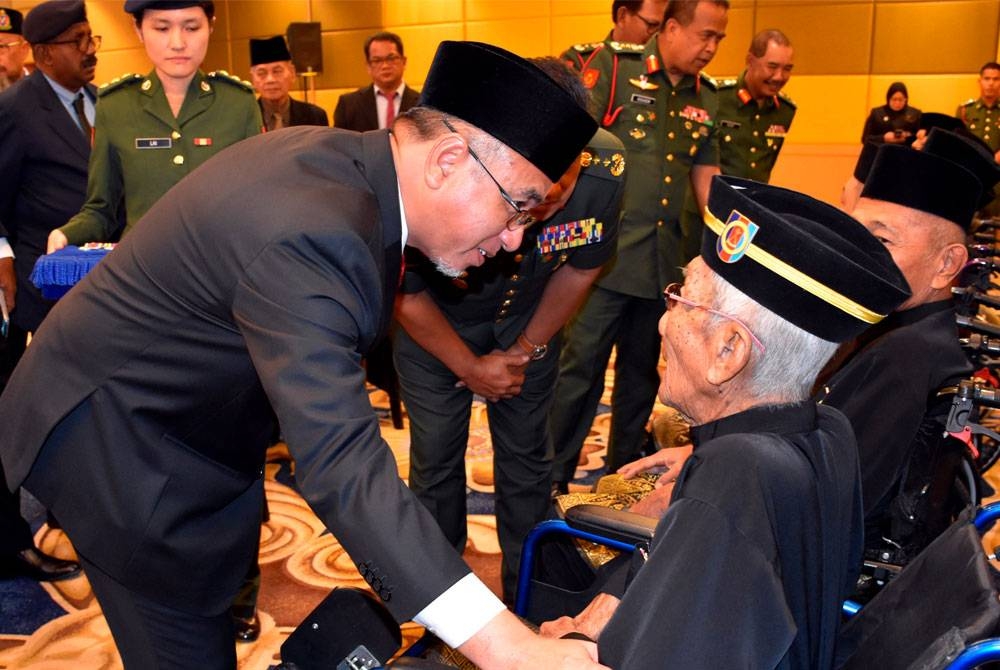 Adly Zahari (kiri) beramah mesra dengan veteran ATM pada Majlis Penganugerahan Pingat Jasa Malaysia (PJM) di Pusat Dagangan Antarabangsa Melaka (MITC) pada Ahad. - Foto Bernama